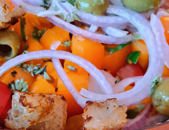 Close-up van Portugese salade met kleurrijke tomaten, knoflookolijven en kruiden